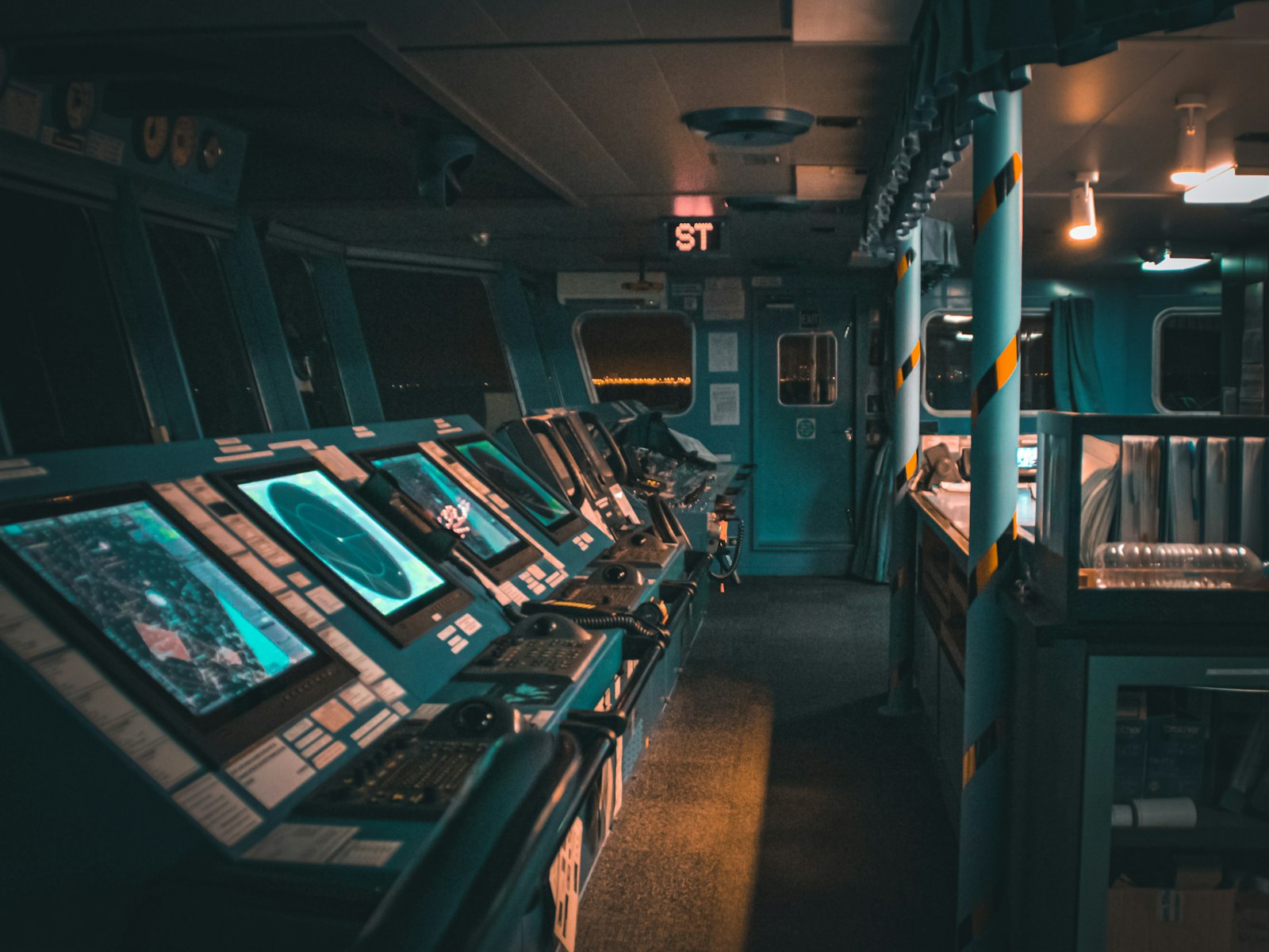 Ship bridge at night with navigation screens glowing